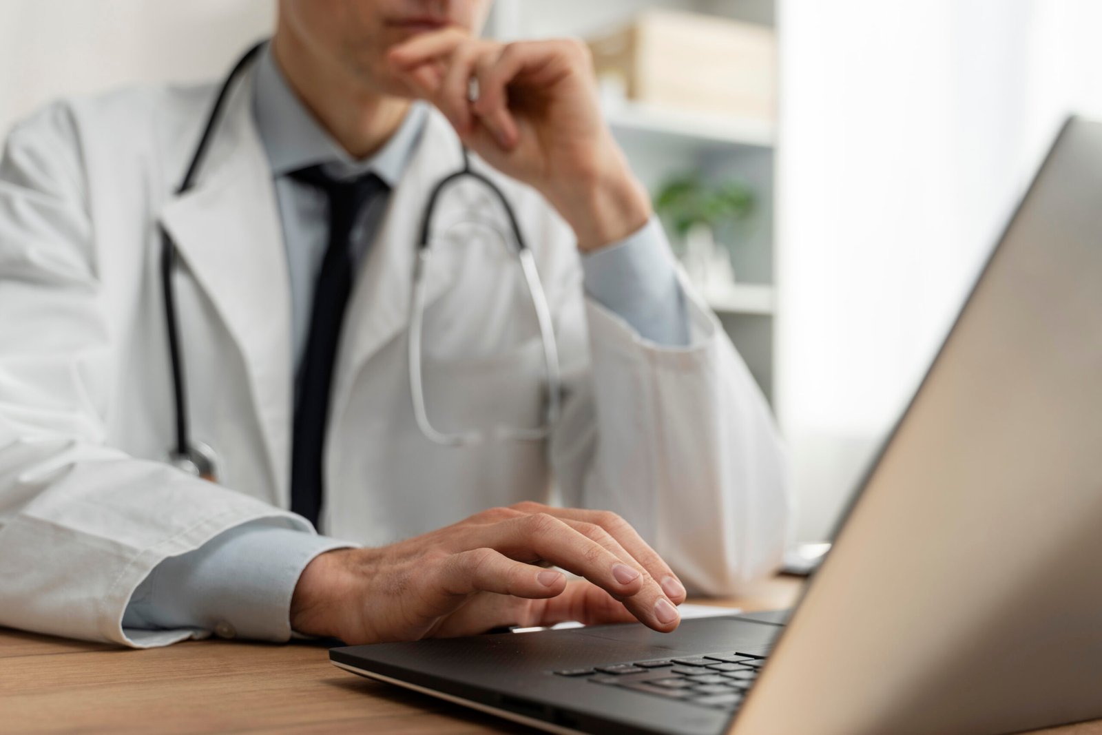 Doctor frente a laptop ofreciendo teleconsulta geriátrica en línea